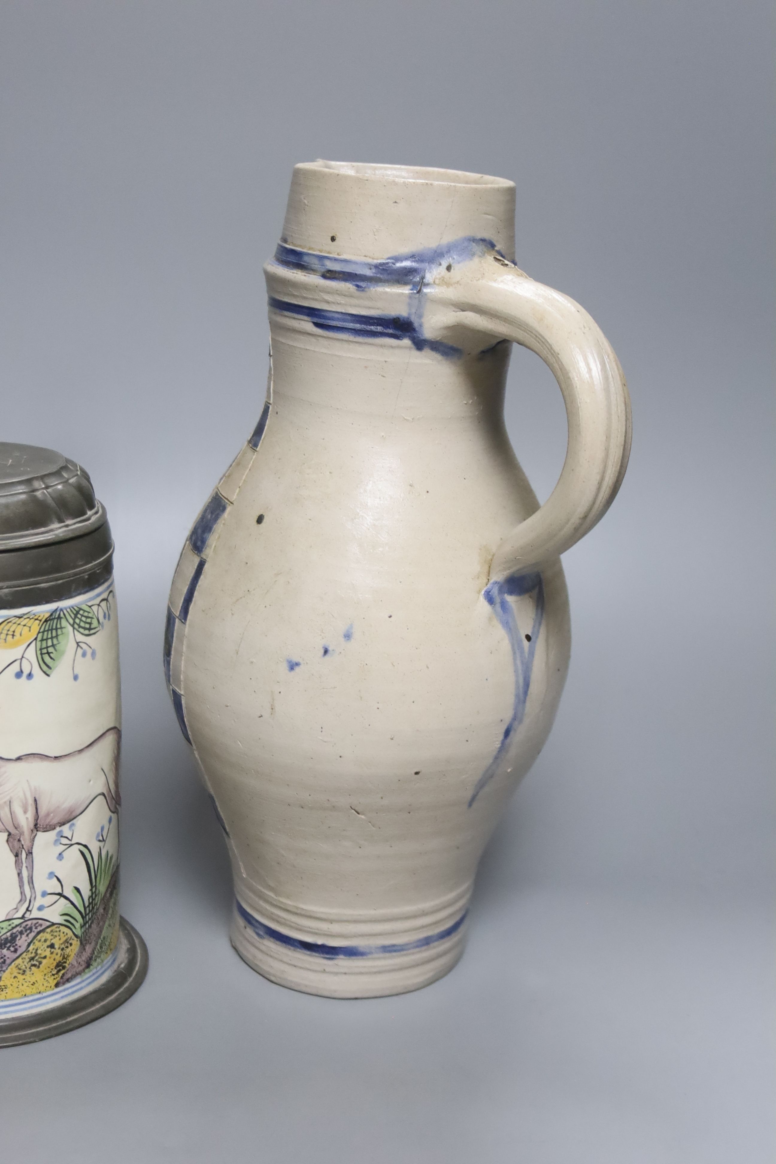 An 18th/19th century German faience pewter-mounted stein decorated with a stag and a German stoneware pitcher, height 25cm & 30cm